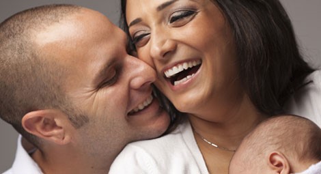 Smiling parents holding a baby